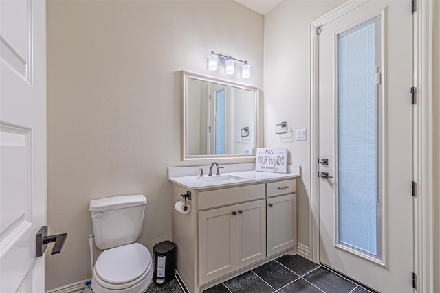 half bathroom with toilet, tile patterned floors, and vanity