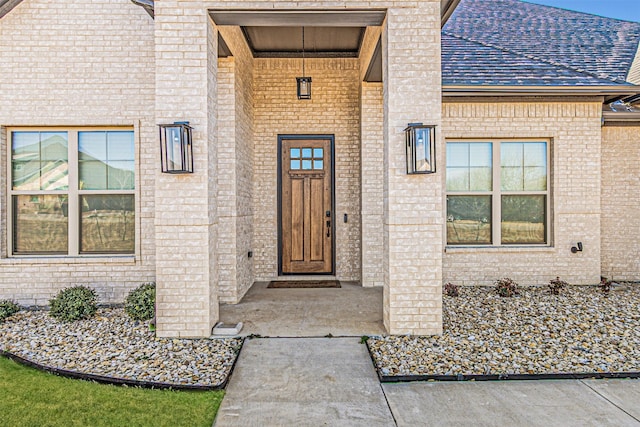 doorway to property featuring brick siding