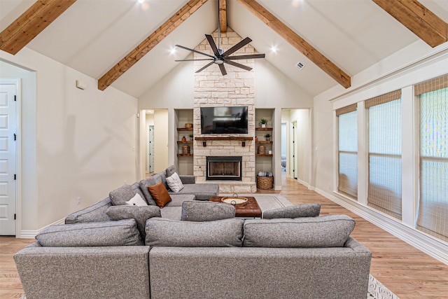 living room with high vaulted ceiling, a fireplace, and light wood-style floors