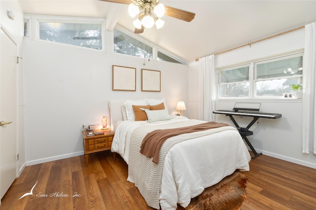 bedroom with vaulted ceiling, dark wood finished floors, and baseboards