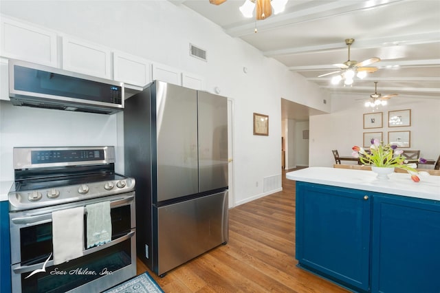 kitchen featuring visible vents, lofted ceiling with beams, appliances with stainless steel finishes, blue cabinets, and light countertops