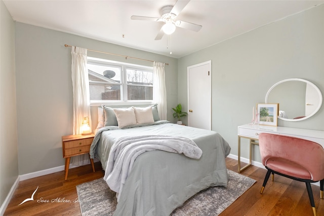 bedroom with ceiling fan, wood finished floors, and baseboards