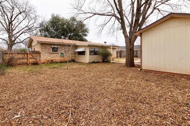 back of property with fence and brick siding