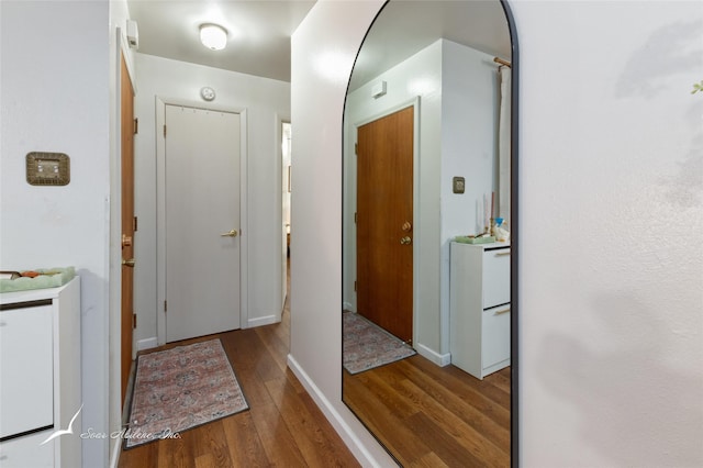 hallway featuring baseboards and wood finished floors