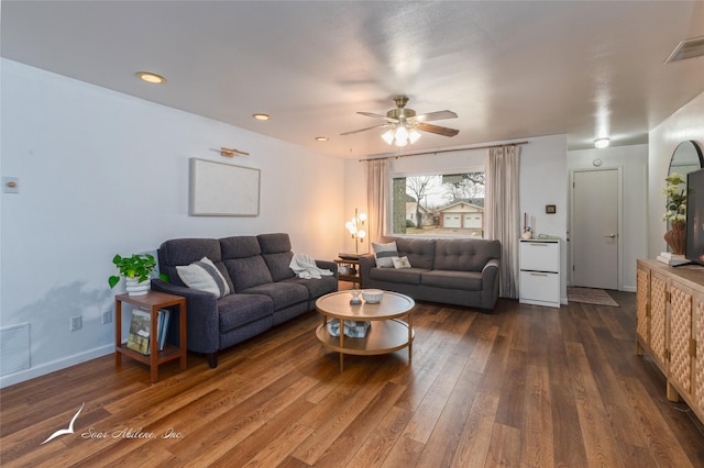 living room with dark wood-style floors, baseboards, visible vents, and ceiling fan