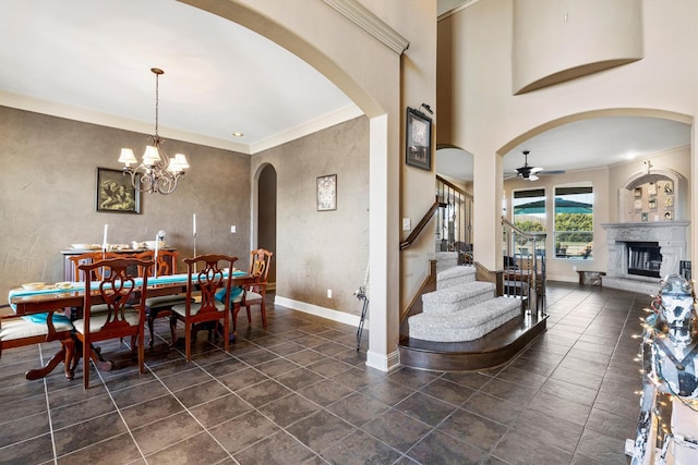 dining room featuring stairs, baseboards, a fireplace with raised hearth, and ornamental molding