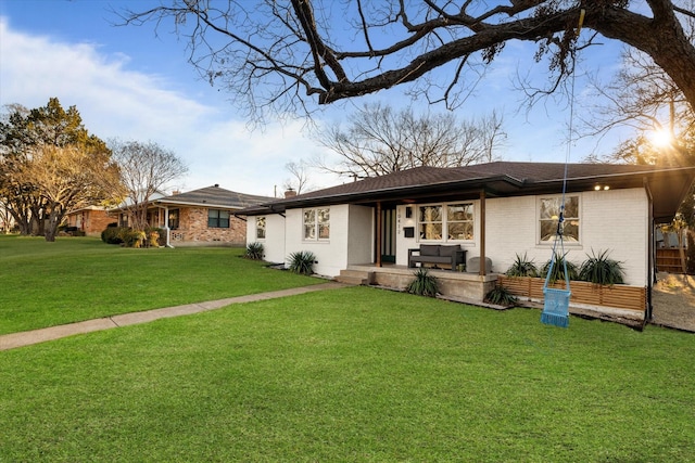 view of front of house featuring a front yard, a chimney, and brick siding