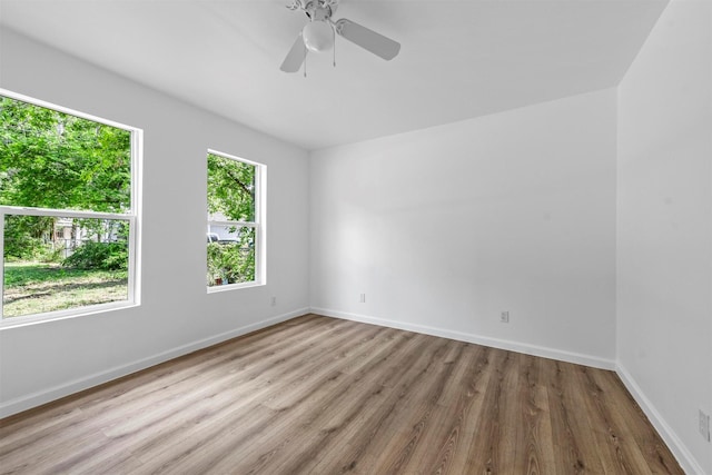 unfurnished room with light wood-style floors, baseboards, and a ceiling fan