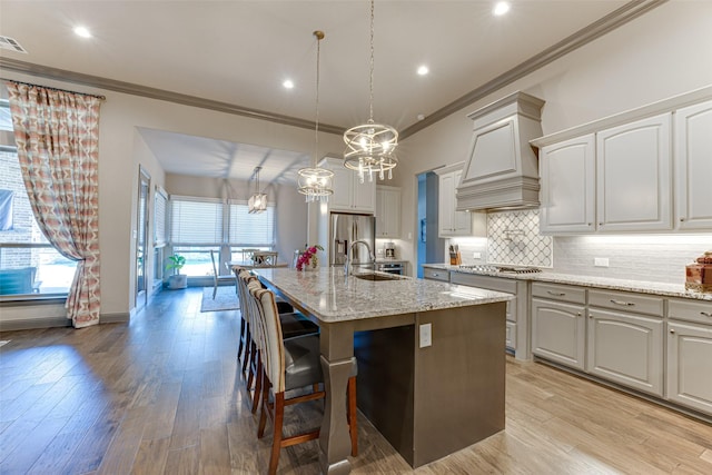 326 Prairie View Rd, Rockwall, TX 75087 - kitchen with crown molding, appliances with stainless steel finishes, premium range hood, and a chandelier