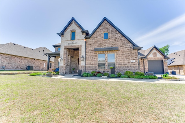 326 Prairie View Rd, Rockwall, TX 75087 - french country home with central AC unit, a front lawn, and brick siding