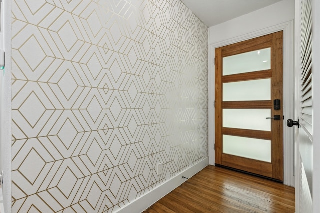 doorway featuring wood finished floors and wallpapered walls