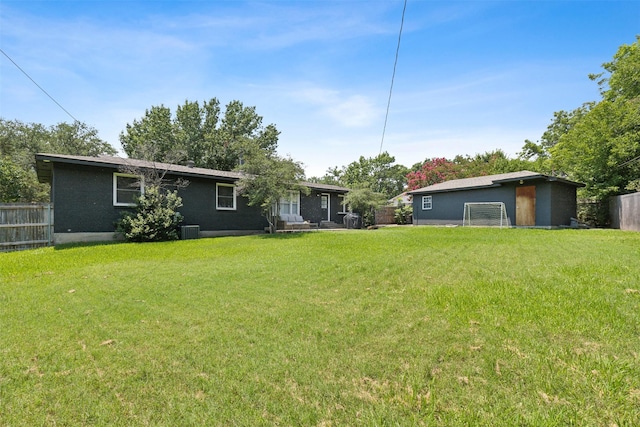 back of property with a yard, fence, and central AC unit