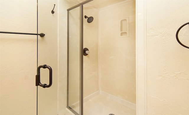 full bathroom featuring a textured wall and a shower stall