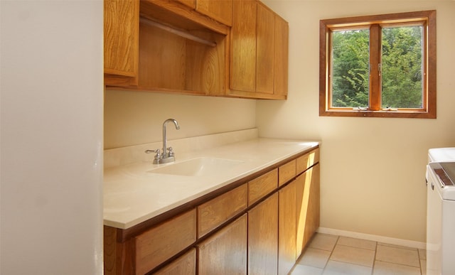 interior space with brown cabinetry, washing machine and dryer, light countertops, and a sink