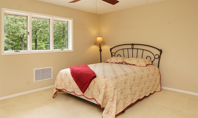 carpeted bedroom with ceiling fan, visible vents, and baseboards