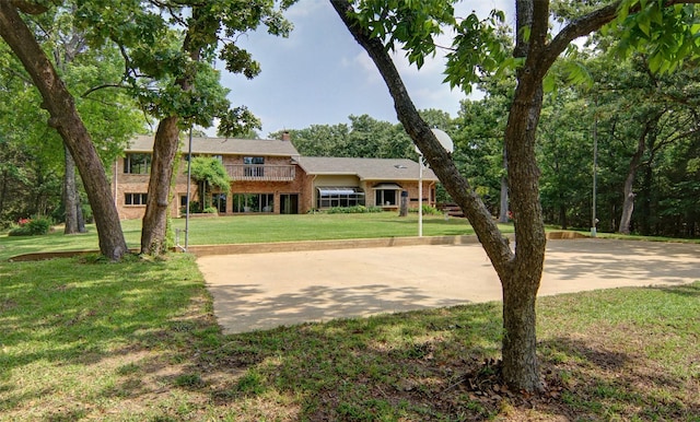 view of front of house with a chimney, a front lawn, and brick siding