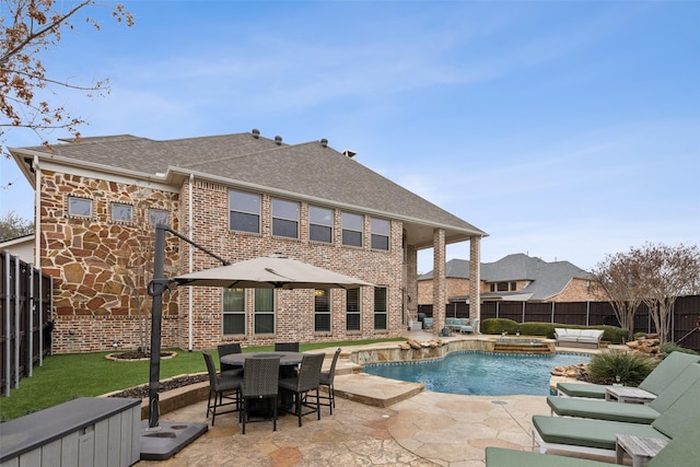 view of swimming pool with a patio, a fireplace, a fenced backyard, and an in ground hot tub