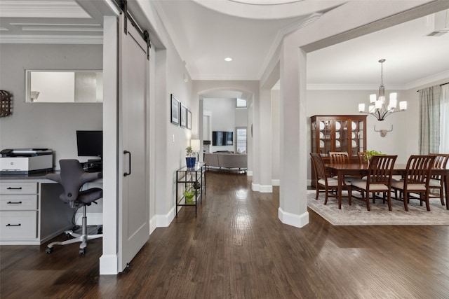 interior space with dark wood-style floors, a barn door, ornamental molding, and visible vents