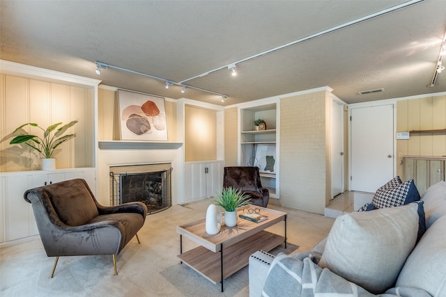 430 Mayrant Dr, Dallas, TX 75224 - living room with built in shelves, rail lighting, a fireplace with flush hearth, a textured ceiling, and carpet