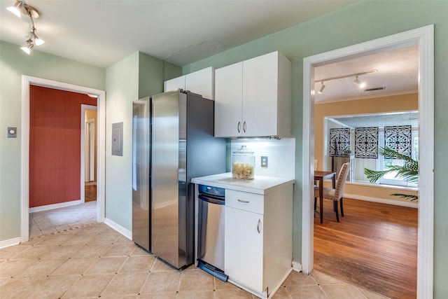 430 Mayrant Dr, Dallas, TX 75224 - kitchen featuring track lighting, freestanding refrigerator, light countertops, light tile patterned floors, and white cabinetry