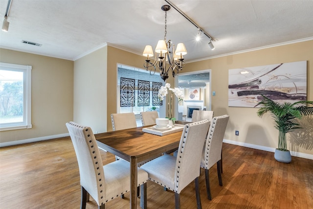 430 Mayrant Dr, Dallas, TX 75224 - dining space with rail lighting, a chandelier, wood finished floors, baseboards, and ornamental molding