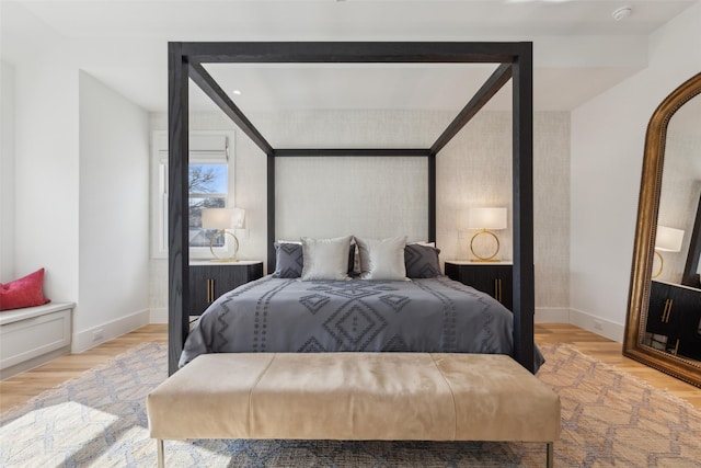 bedroom featuring baseboards and light wood finished floors