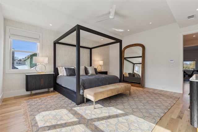 bedroom featuring light wood-style flooring, visible vents, ceiling fan, and baseboards