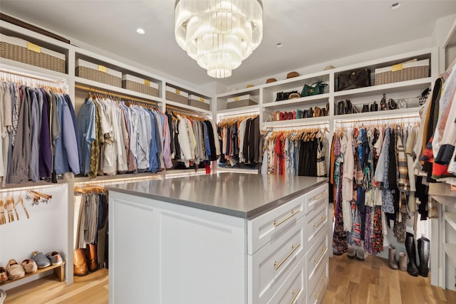 spacious closet featuring a chandelier and light wood-style flooring