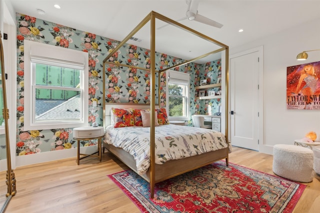 bedroom with wallpapered walls, baseboards, wood finished floors, and recessed lighting