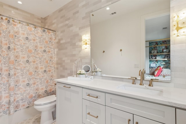 bathroom featuring double vanity, curtained shower, visible vents, toilet, and a sink