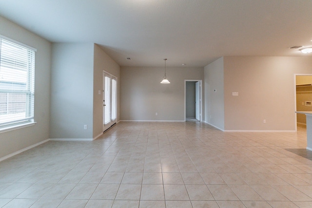 empty room with visible vents, baseboards, and light tile patterned floors