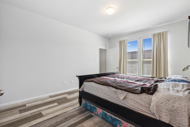 bedroom featuring baseboards and wood finished floors