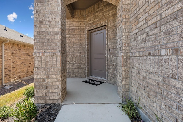 doorway to property featuring brick siding