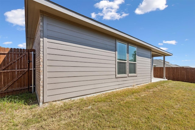 view of property exterior with a lawn and fence