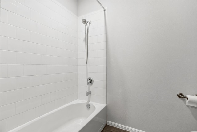 full bathroom featuring bathtub / shower combination and baseboards