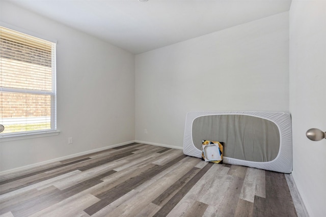 spare room featuring baseboards and wood finished floors