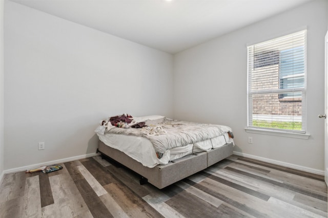 bedroom featuring baseboards and wood finished floors