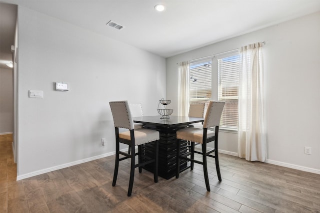 dining area with visible vents, dark wood finished floors, and baseboards