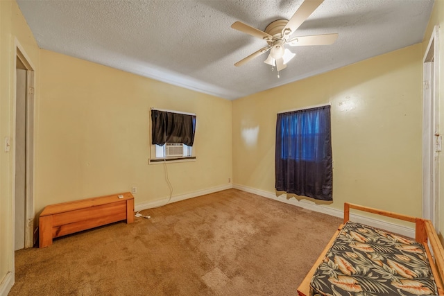 bedroom featuring light carpet, ceiling fan, a textured ceiling, and baseboards