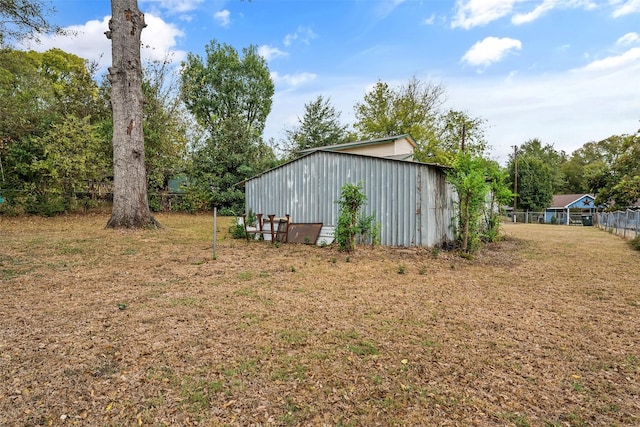 view of yard with fence and an outbuilding