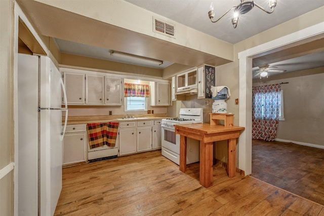 kitchen featuring white appliances, visible vents, light wood-style floors, white cabinets, and light countertops