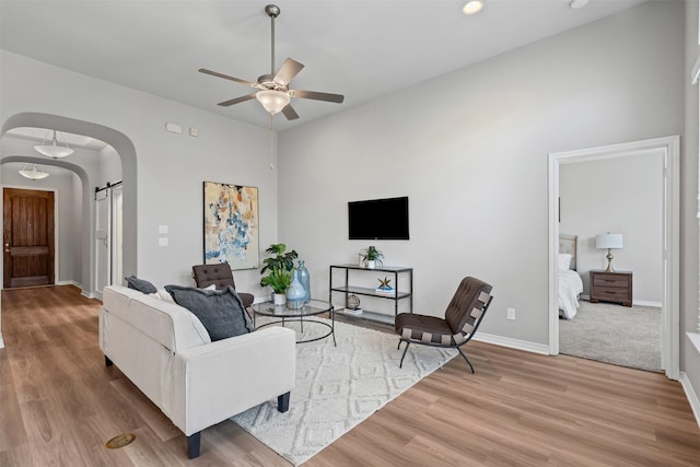 813 Louisville Rd, Aubrey, TX 76227 - living area with arched walkways, ceiling fan, wood finished floors, baseboards, and a towering ceiling