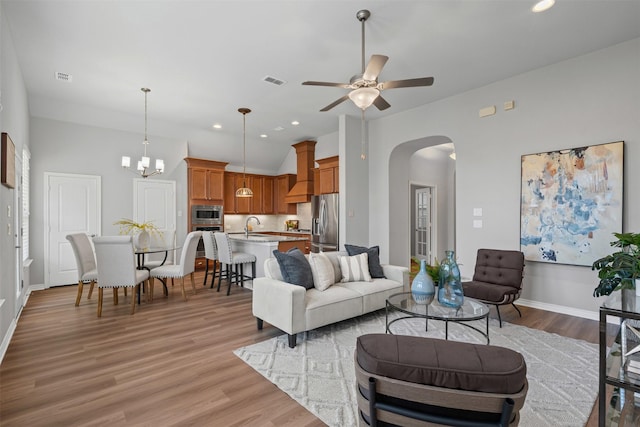 813 Louisville Rd, Aubrey, TX 76227 - living room featuring arched walkways, light wood-style floors, ceiling fan, baseboards, and vaulted ceiling