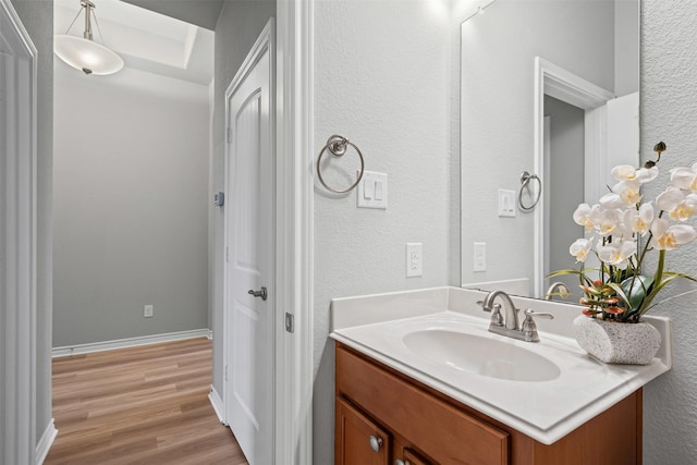 813 Louisville Rd, Aubrey, TX 76227 - bathroom with vanity, wood finished floors, a textured wall, and baseboards