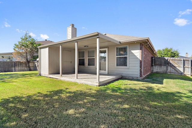 back of property with brick siding, a lawn, a chimney, and a fenced backyard