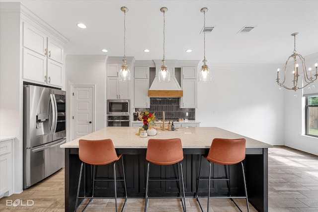 kitchen featuring a kitchen island with sink, visible vents, white cabinets, appliances with stainless steel finishes, and custom range hood