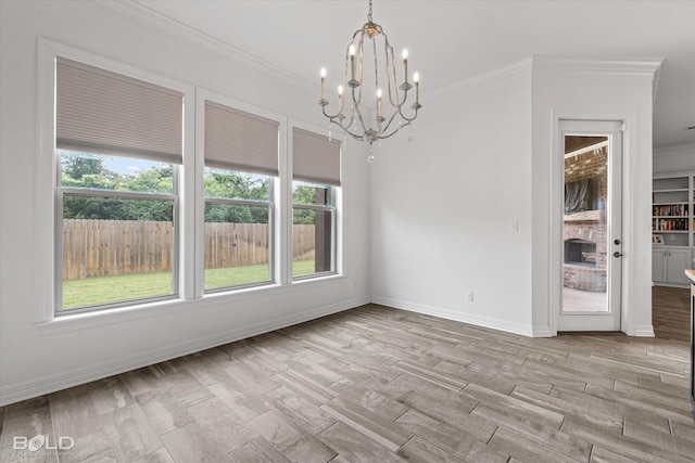 spare room featuring baseboards, an inviting chandelier, light wood-style flooring, and crown molding