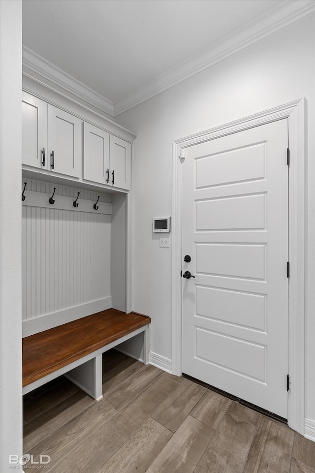 mudroom featuring ornamental molding, baseboards, and light wood finished floors