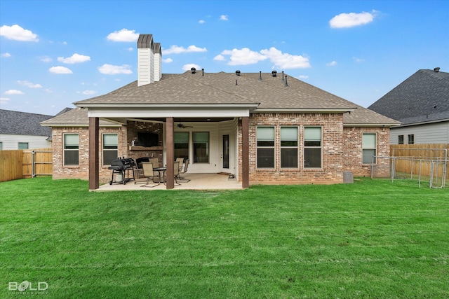 back of house featuring brick siding, a yard, roof with shingles, a patio area, and a fenced backyard