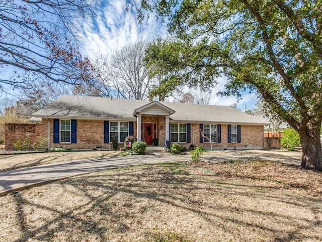 ranch-style house with roof with shingles and brick siding